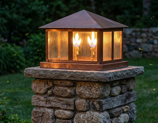 Decorative outdoor light fixture on a stone pedestal with a warm glow.