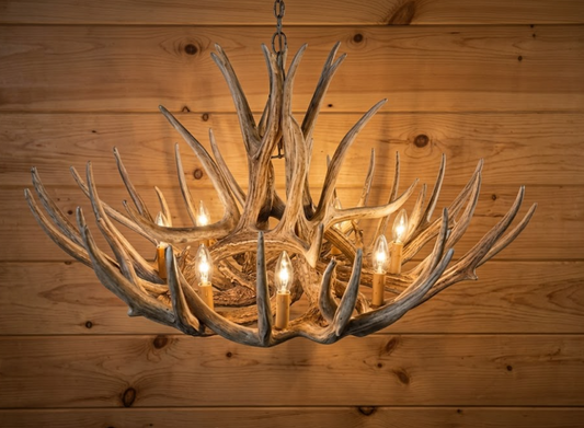 faux deer Antler chandelier hanging against a wooden wall