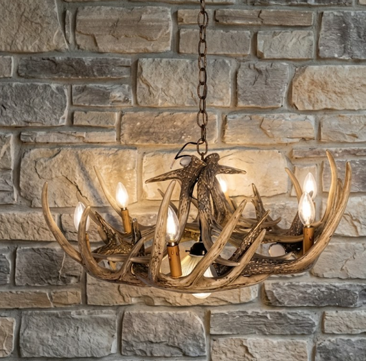 faux deer Antler chandelier with candles against a stone wall background