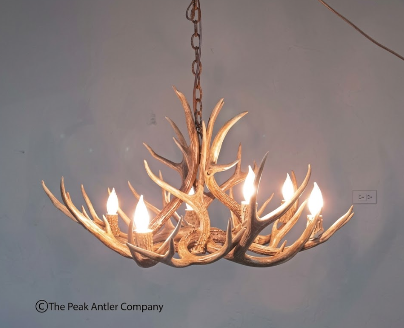 Antler chandelier with multiple lights on a plain background, branded 'The Peak Antler Company'.