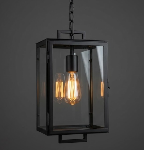 Black pendant light with clear glass shade on a dark background