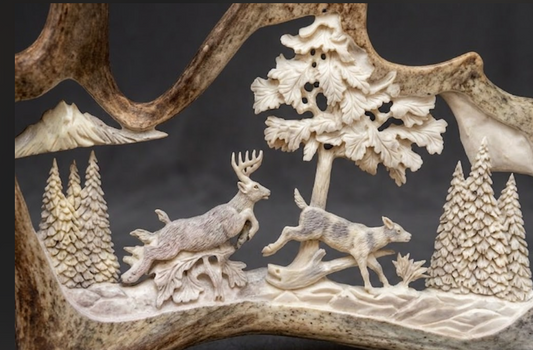 Carved scene of white tail deer and trees on a dark background