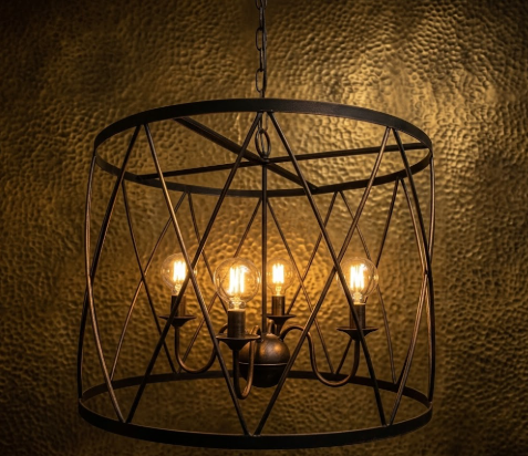 Decorative foyer entryway kitchen island pendant light or chandelier with four lit bulbs against a textured wall.