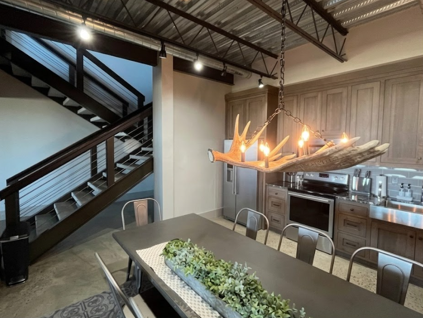 Modern kitchen with wooden dining table and decorative Faux moose light fixture.