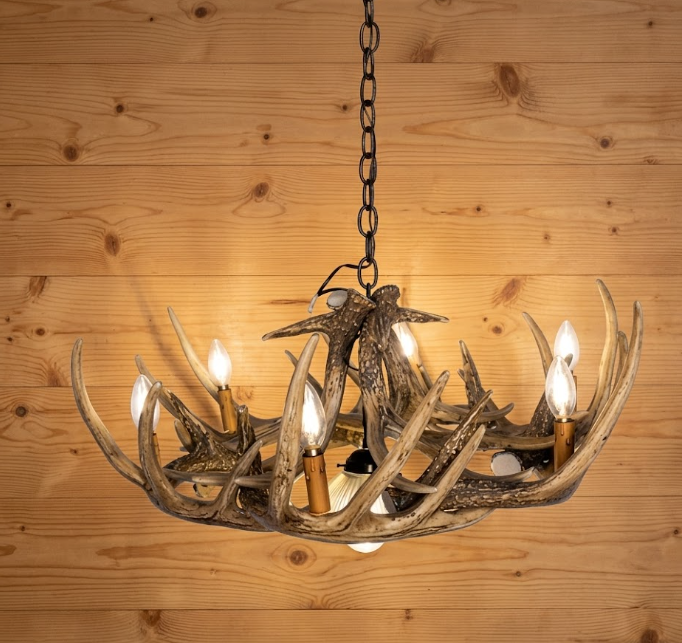 faux deer Antler chandelier with six lights on a wooden background