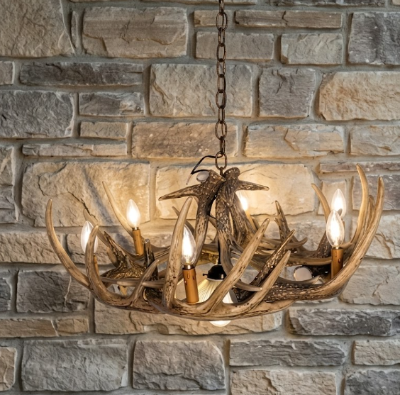 faux deer Antler chandelier with candles against a stone wall background