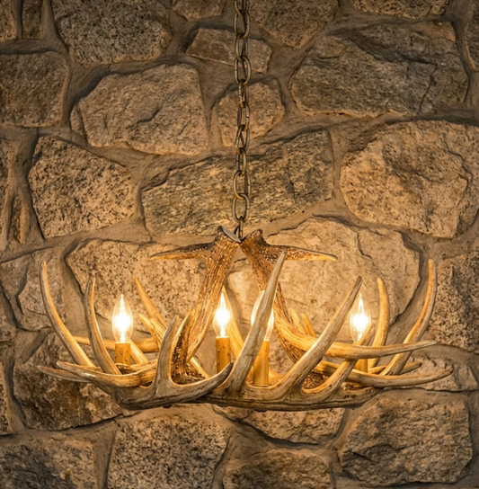 Faux deer Antler chandelier hanging against a stone wall