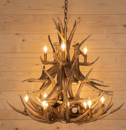 faux deer Antler chandelier with multiple lights on a wooden wall background