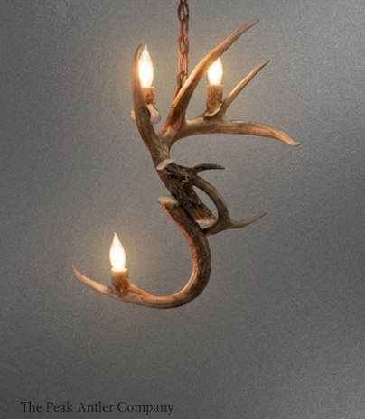 Antler-shaped chandelier with three lights on a gray background, branded 'The Peak Antler Company'.