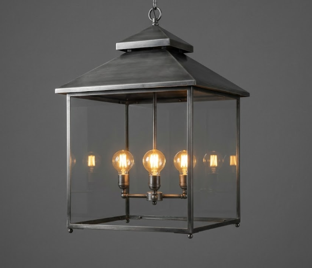 Decorative hanging Kitchen Island Pendant Light Fixture lantern with three lit bulbs on a dark background