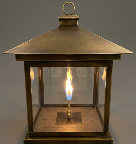 Bronze pendant lantern with a flame inside on a gray background