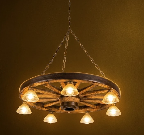 Rustic faux wagon wheel Chandelier made from an old wagon wheel with multiple light bulbs on a dark background