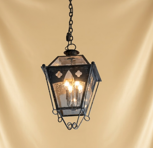 Vintage-style hanging pendant light lantern with glass panels on a beige background