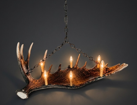 Faux moose antler Chandelier made from antlers with candles on a dark background