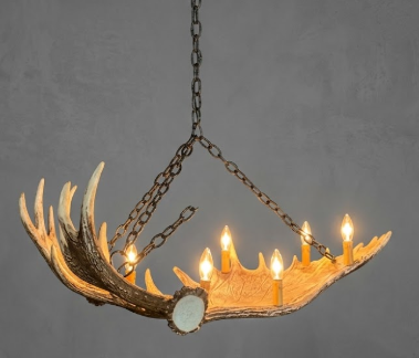 Faux moose Antler-shaped chandelier with lights on a gray background