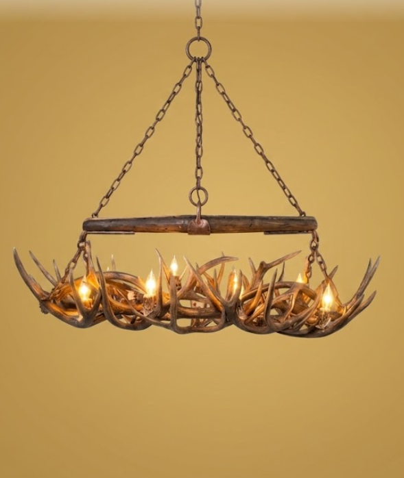 Ox Yoke Beam Deer Antler chandelier with warm lighting on a beige background