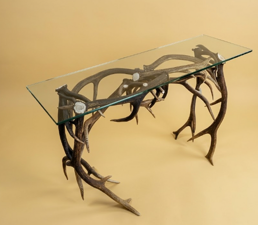 Glass-top sofa/console table  with antler design on a beige background