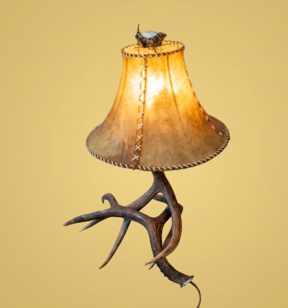 Lamp with antler base and brown lampshade on a beige background