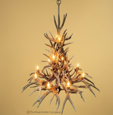 multi tier deer Antler chandelier with lights on a beige background
