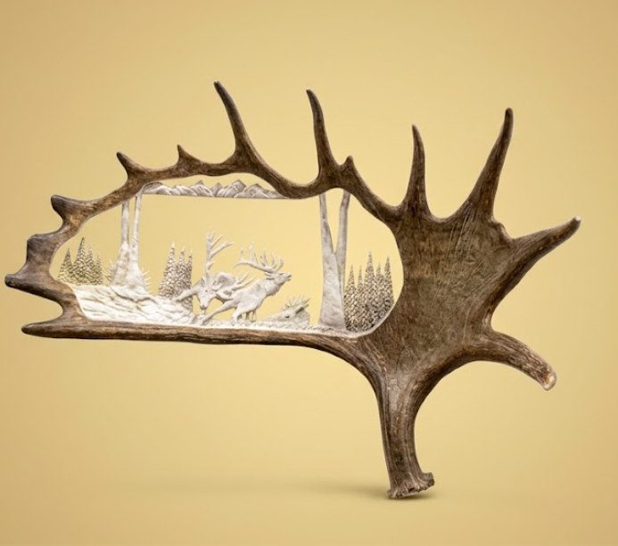 Decorative antler with a silver inset of deer in a forest on a beige background
