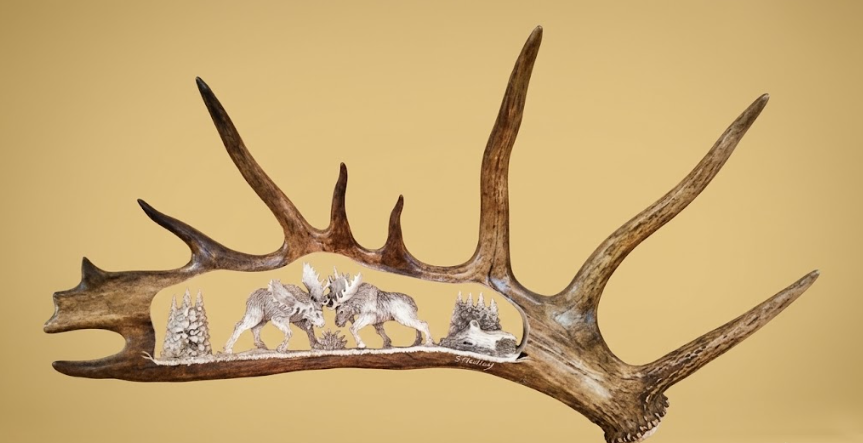 Decorative wall art with deer antlers and embossed animals on a beige background