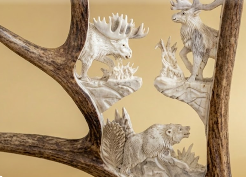 Decorative wall art with caribou, bear, and antlers on a beige background
