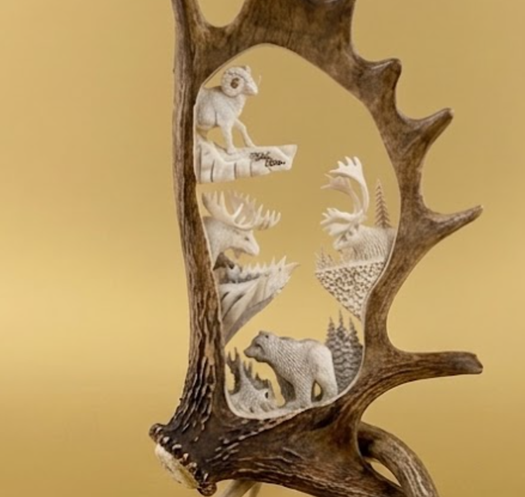 Decorative antler with carvings of animals on a gold background