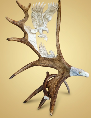 Decorative wall or table art of  moose antlers carved into eagles on a beige background