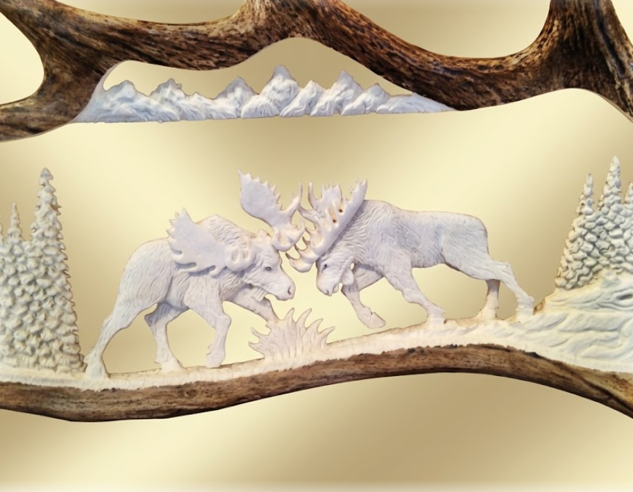 Carved moose figures on a wooden base with a snowy landscape background