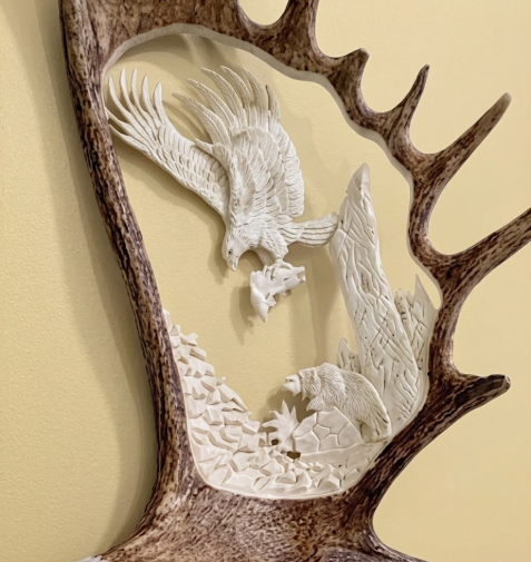 antler carving Decorative wall art with carved eagles and deer antlers on a beige background