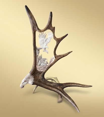 Moose antler carving with an eagles head base on a golden background.