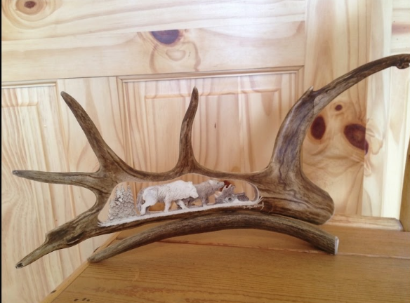 Small carving of two wolves on the hunt carved from a caribou antler.  