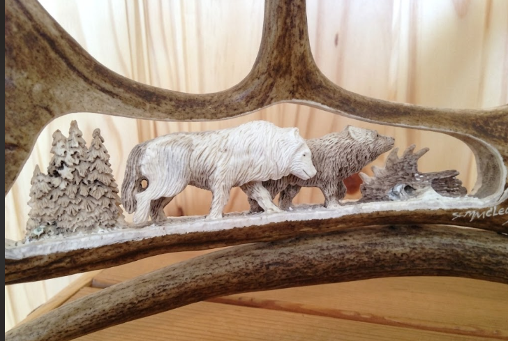  Two wolves carved from a shed caribou antler