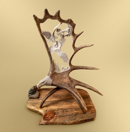  Huge moose antler hand crafted sculpture with fighting eagle design on a beige background
