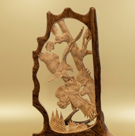 Two eagles fighting hand carved on a moose antler. Tan background