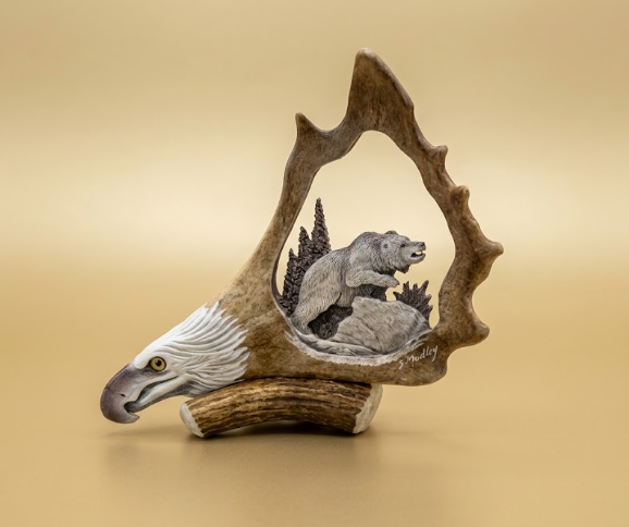 Decorative sculpture of a bear in a tree with an eagle's head on a beige background