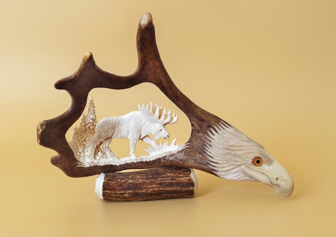 Eagle head small caribou antler moose carving on a golden background.