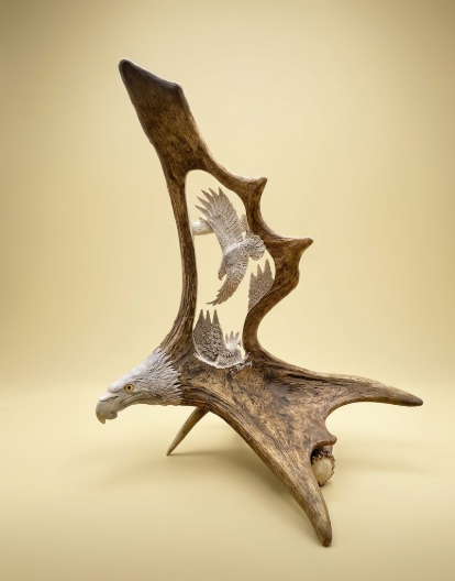 Exquisite  eagle head moose antler carving with a soaring eagle, on a beige background
