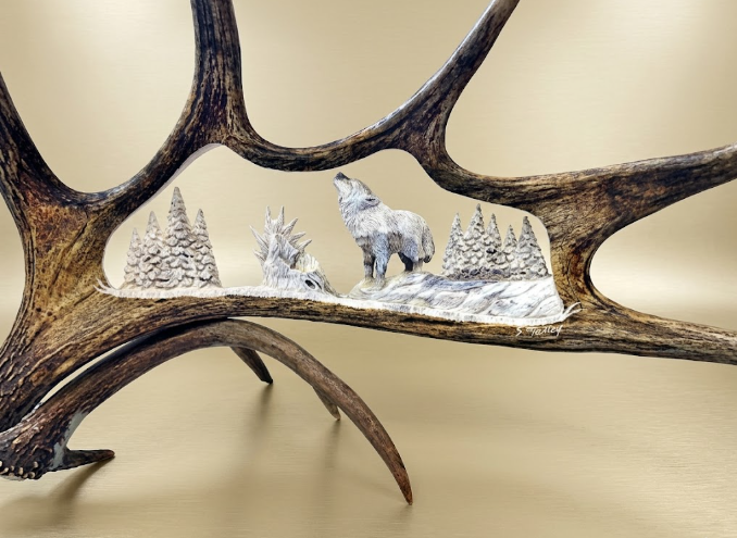 Decorative scene with a wolf and trees on a moose antler against a beige background