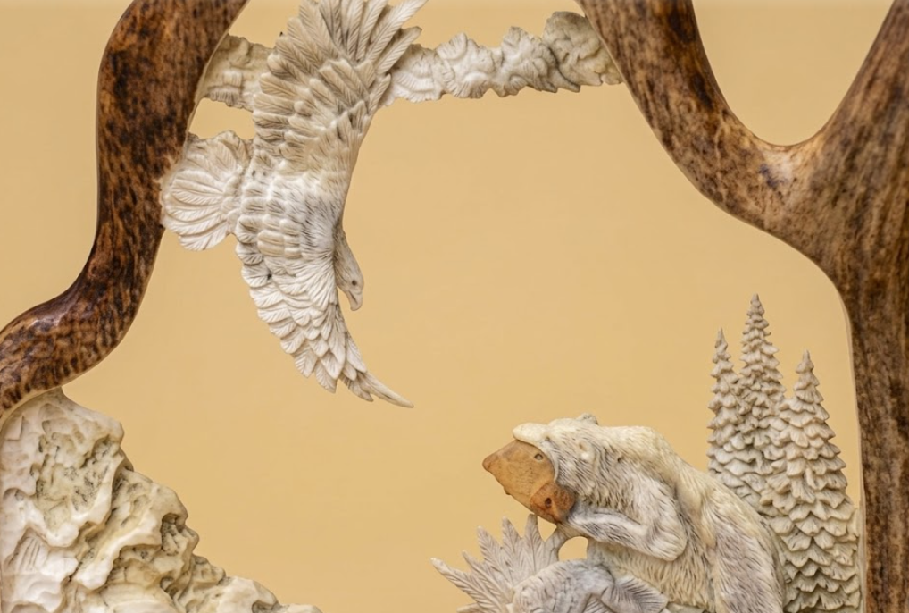 Antler sculpture of a bear and an eagle with a naturalistic design on a beige background