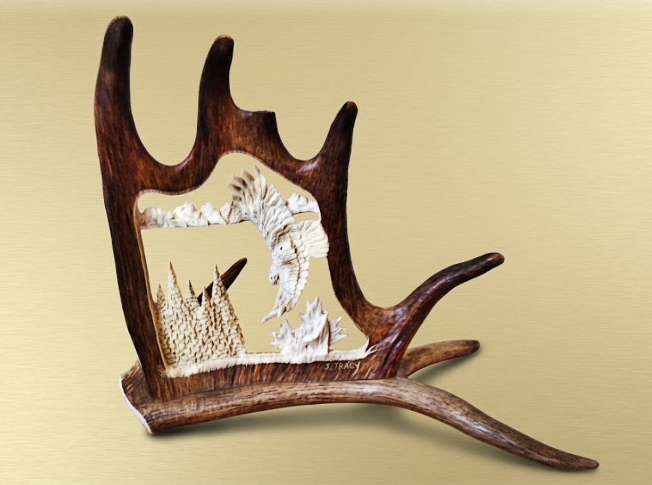 Carved scene on a moose antler of a soaring eagle catching the wind draft, on a beige background