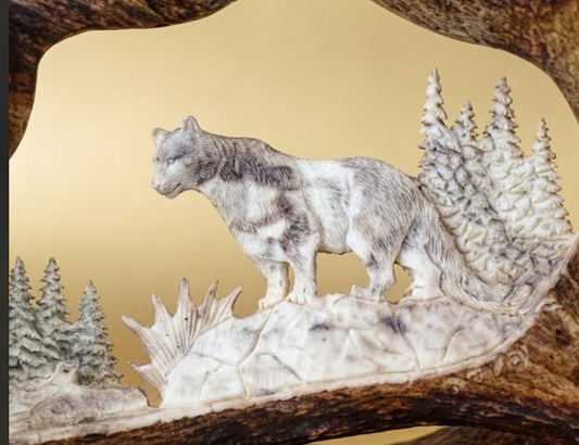 Carved antler plaque with mountain lion and forest design on a natural background