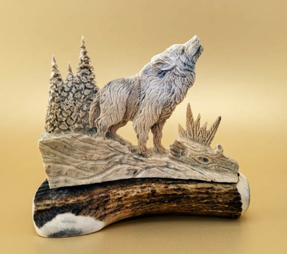 Wolf sculpture on an antler base with a natural landscape background