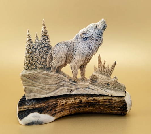 Wolf sculpture on an antler base with a natural landscape background
