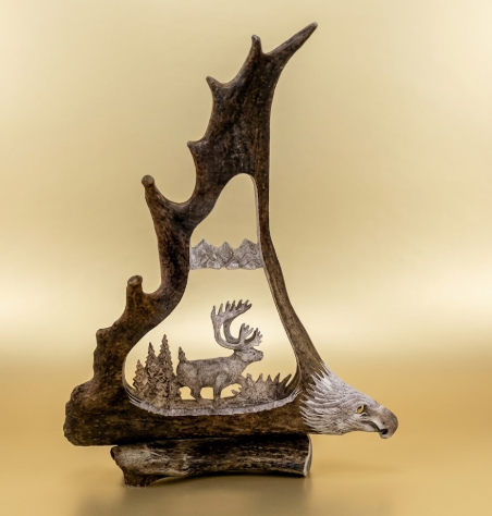 Caribou antler hand carved with a  caribou high country scene and a eagles head  carving on the base.