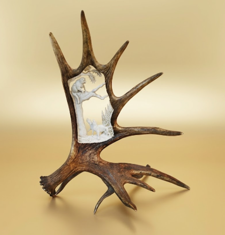 Moose antler carving of treed cougar by a couple of dogs. table mount