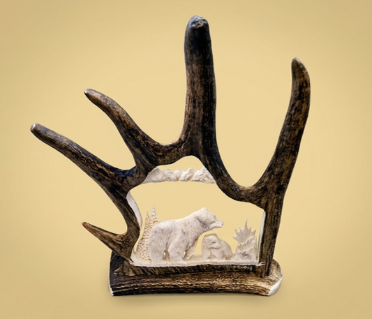 Decorative antler with a carved scene of bears on a beige background