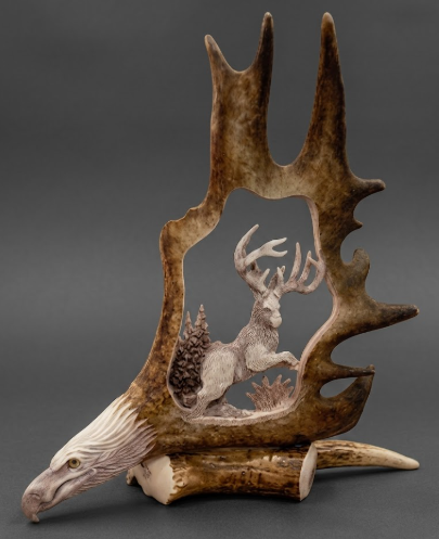 Decorative piece with caribou antlers and a carved eagle head on a gray background