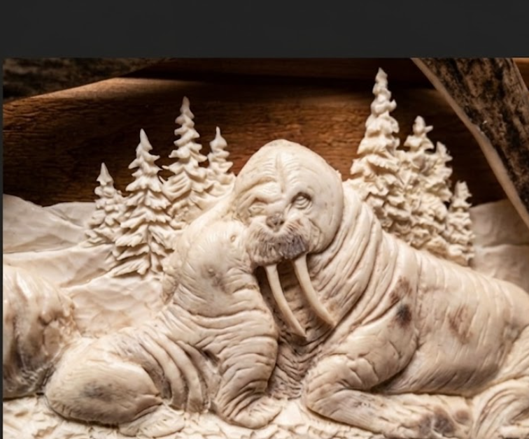 Carved antler sculpture of two walruses in a forest iced setting