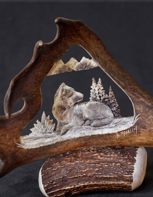 Caribou antler sculpture with engraved wolf and landscape
